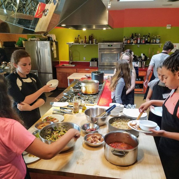 a group of people preparing food on a table