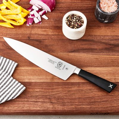 a knife sitting on top of a wooden cutting board