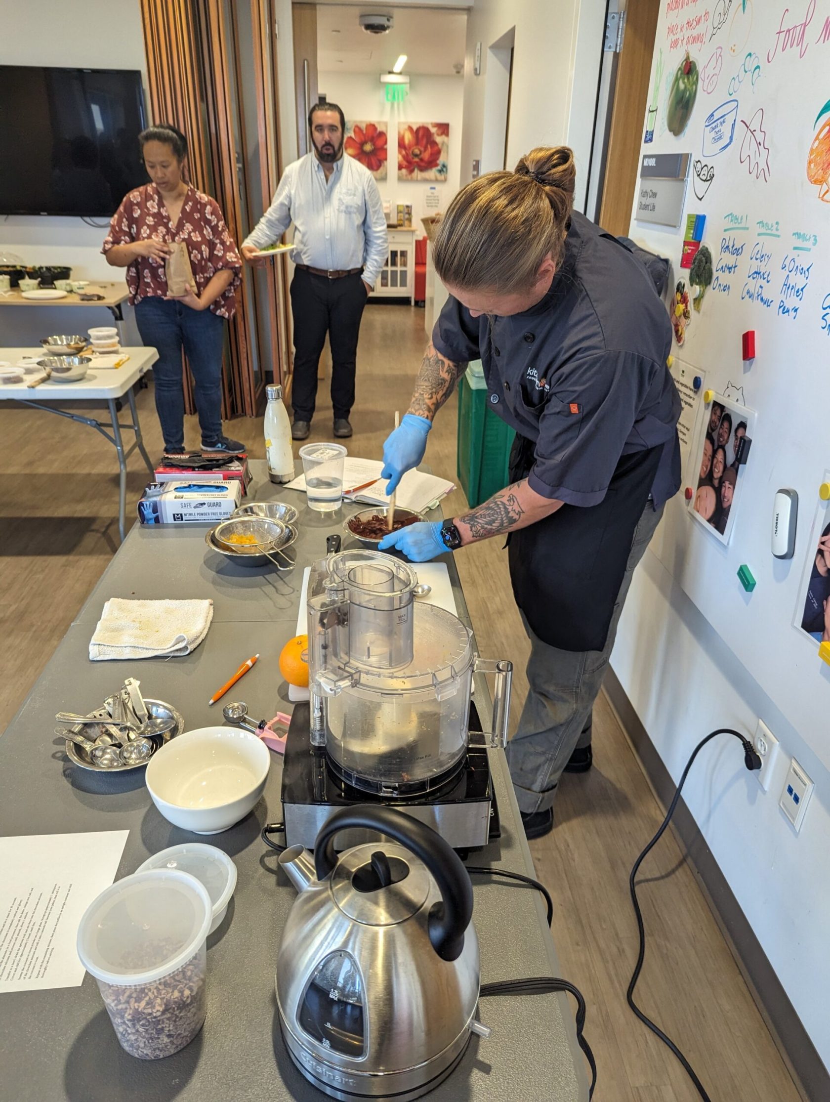 a group of people standing around a table