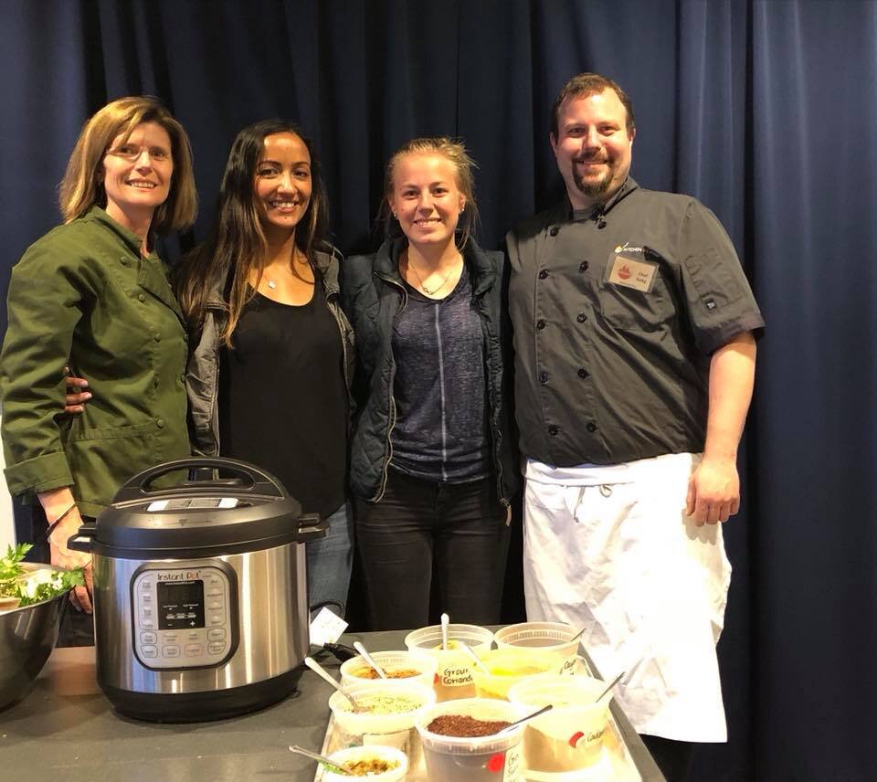 a group of people standing in front of a cake