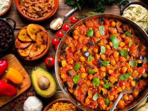 Colorful chickpea stew in a pan, surrounded by various vegetables and sides.